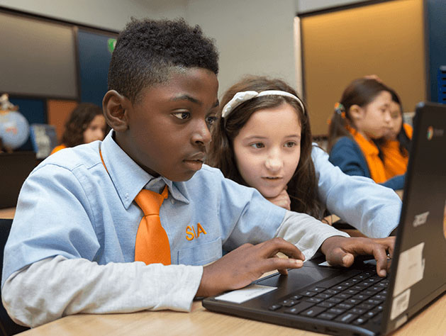 Discover our NY public charter schools - Young scholars working together on computer in the classroom