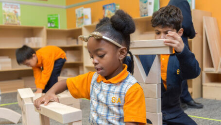 elementary students stacking wood blocks